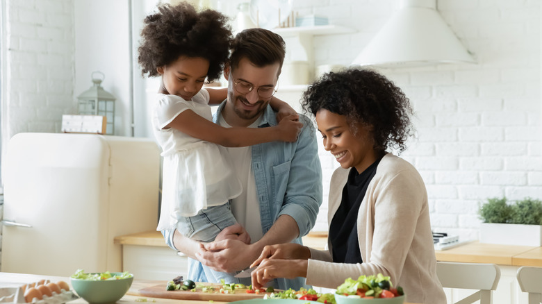 Parents and daughter cooking together