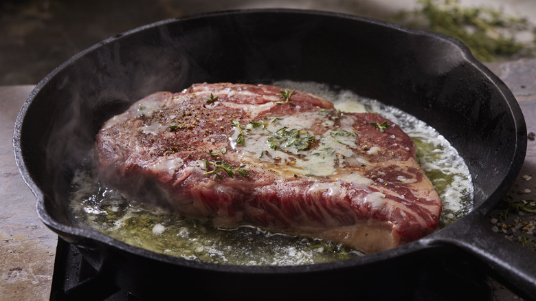 searing steak in iron pan