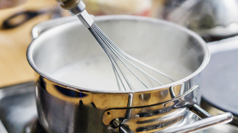 heating milk on a stove with whisk