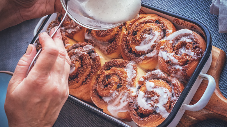 hand frosting homemade cinnamon rolls