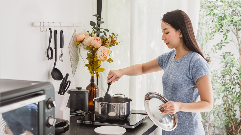 woman stirring soup on stove