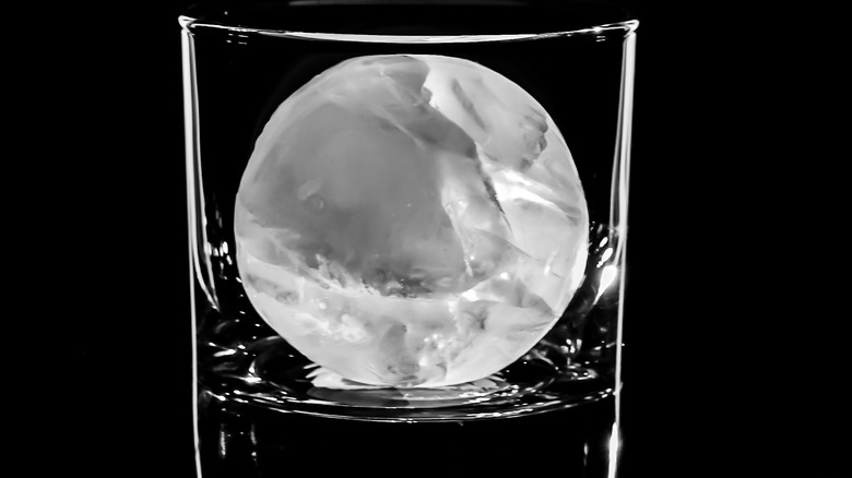 Large ice sphere in cocktail glass