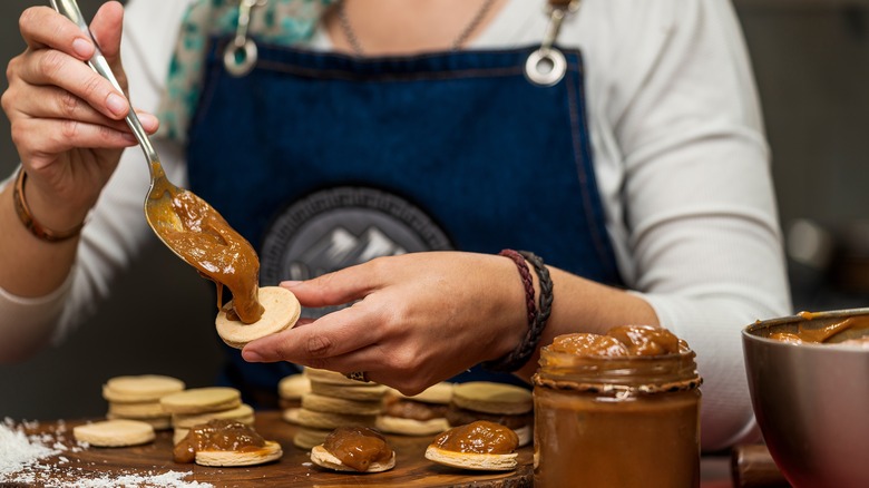 Woman fills alfajores with dulce