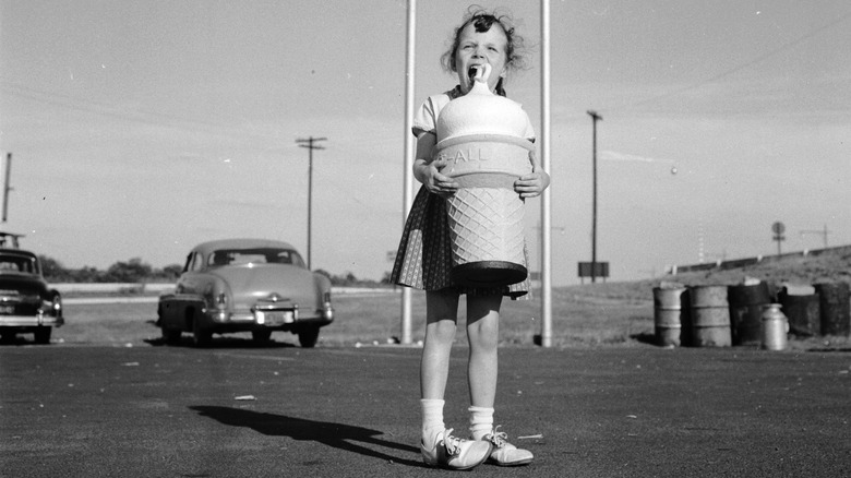 girl holding huge plastic ice cream cone