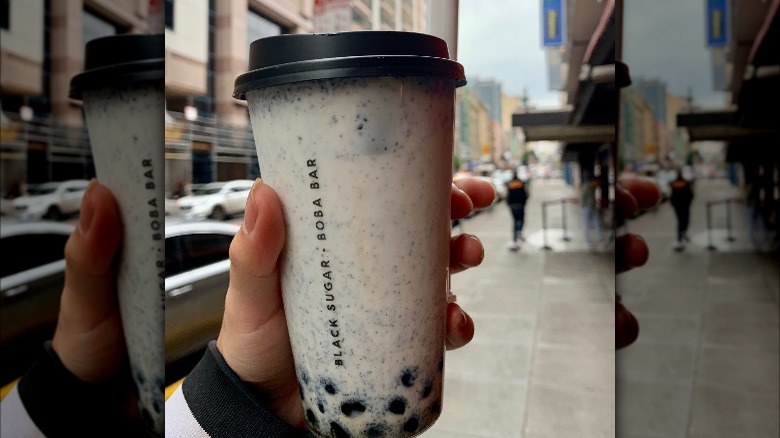 Black sesame bubble tea being held