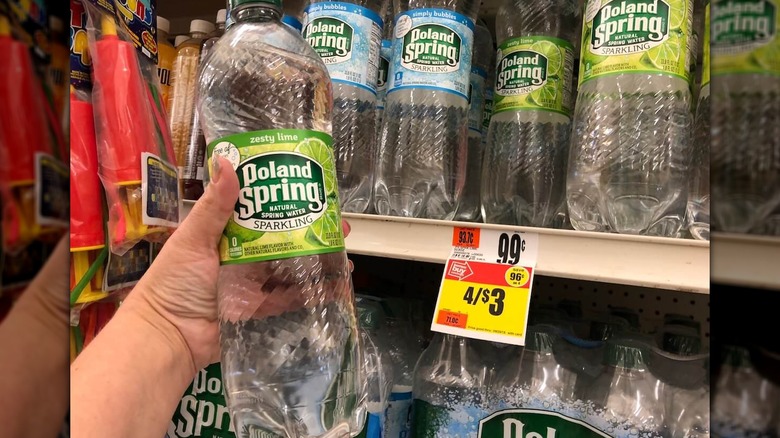 Person holding sparkling water bottle
