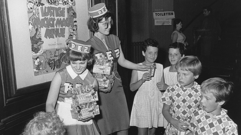 Woman handing PEZ candy to children