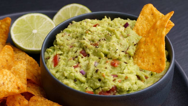 Guacamole dip with chips and lime