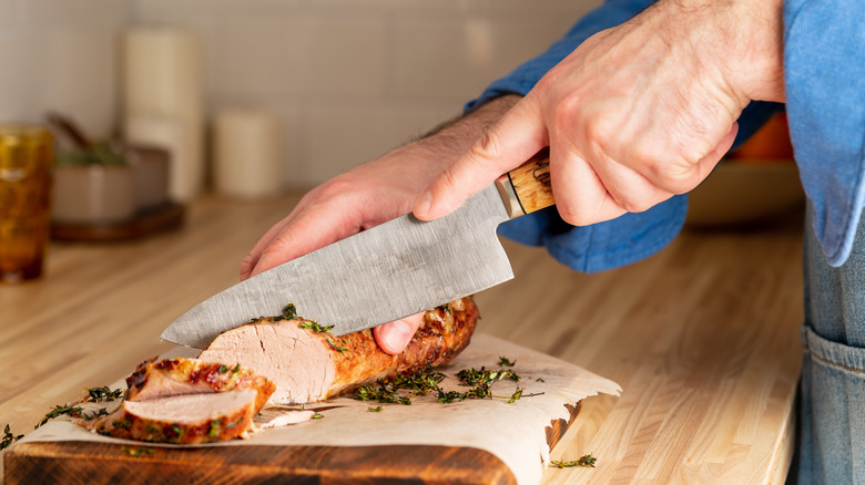 Man cuts pork tenderloin 