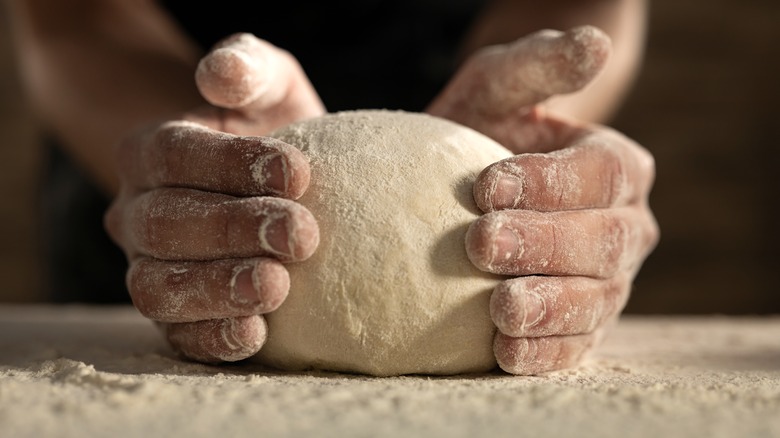 Hands kneading pizza dough