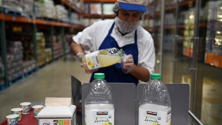 Costco representative pours lemonade