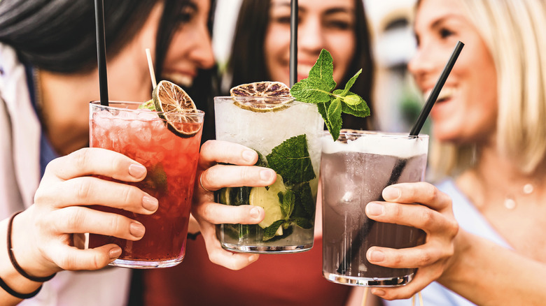 Women clinking glasses of mixed drinks