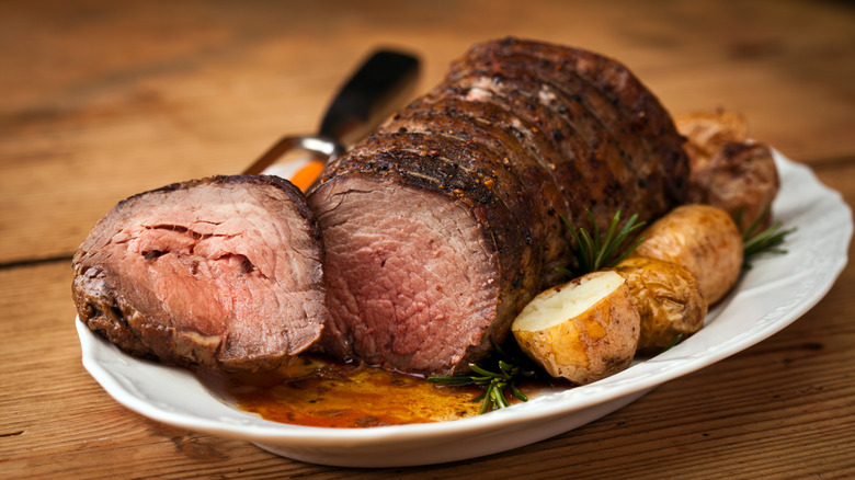 Sliced roast beef and potatoes on a plate