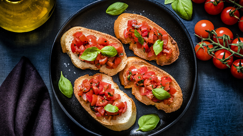 Aerial view of bruschetta on blue plate and blue tablecloth