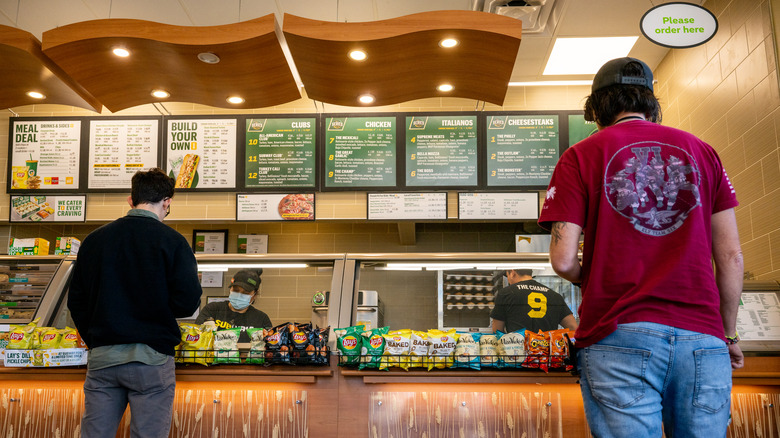 Two customers ordering at Subway