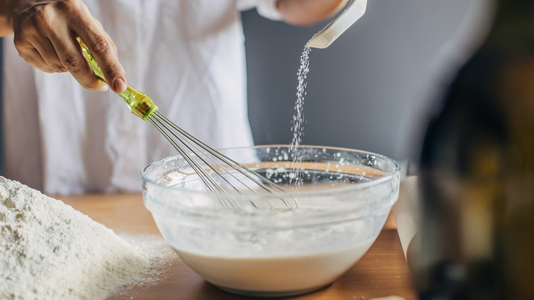 Person whisking dry ingredients