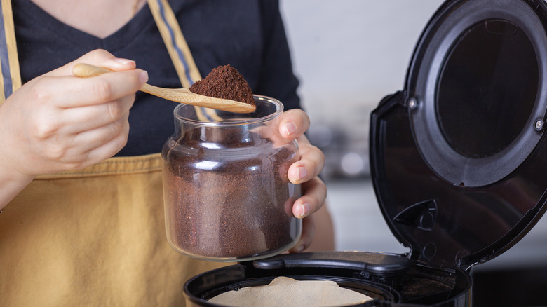 Person measuring ground coffee