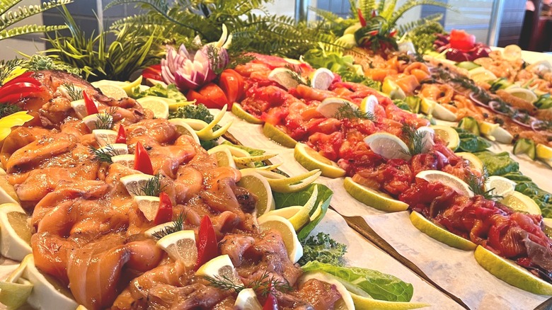 Sliced fish sits on ice at buffet stand.