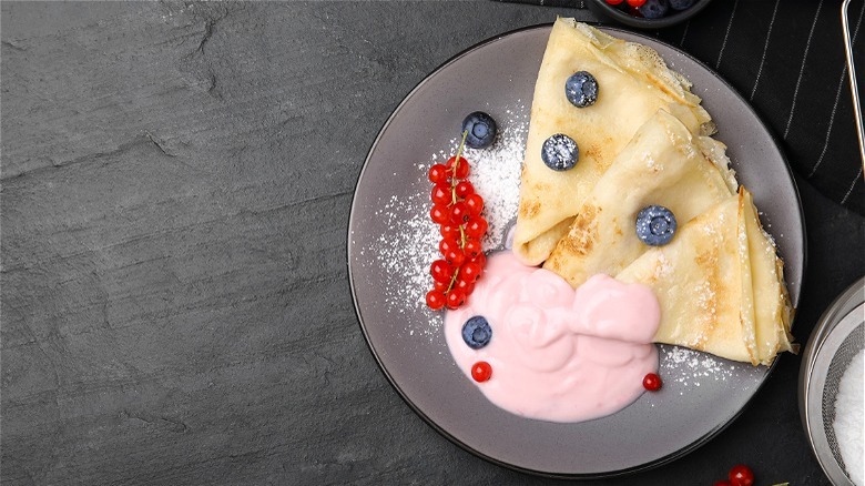 Crepe, yogurt, and fruit on plate 