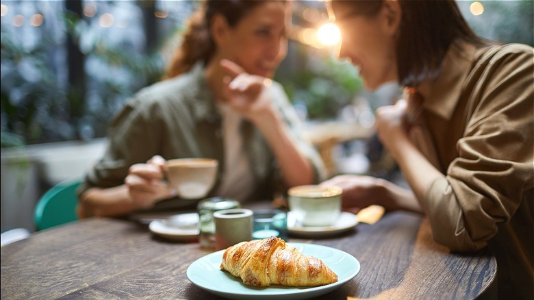 Friends socializing with drinks and croissant