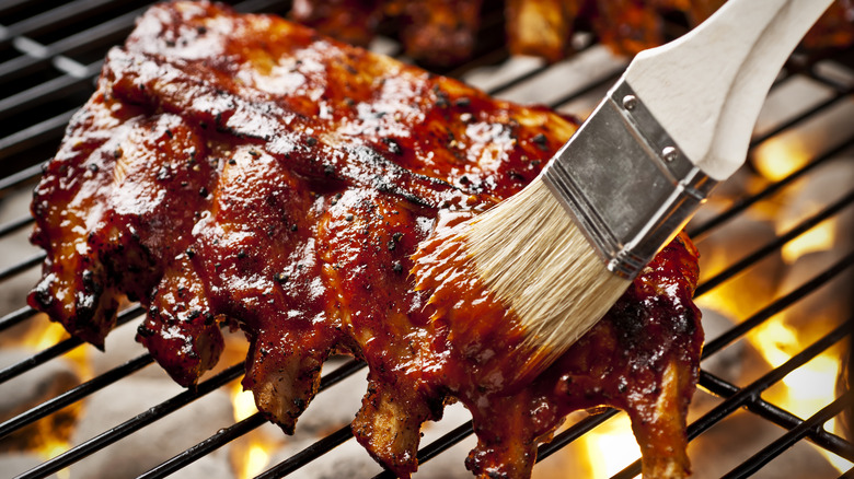 Ribs being brushed on a grill