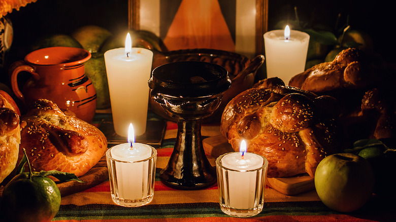 Day of the Day offering with candles, fruit, marigolds, and bread of the dead