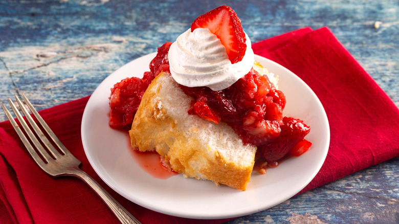 slice of fluffy angel food cake with whipped cream and strawberries