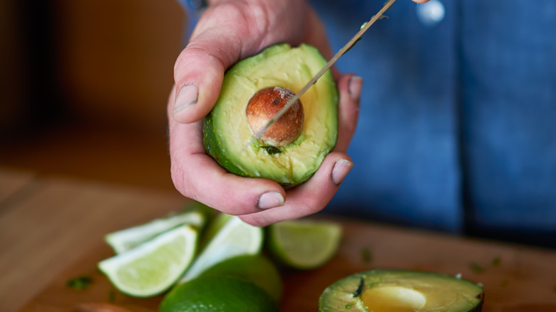 Hands pitting an avocado