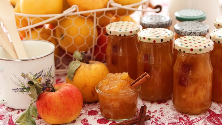 apples and jelly jars on a table