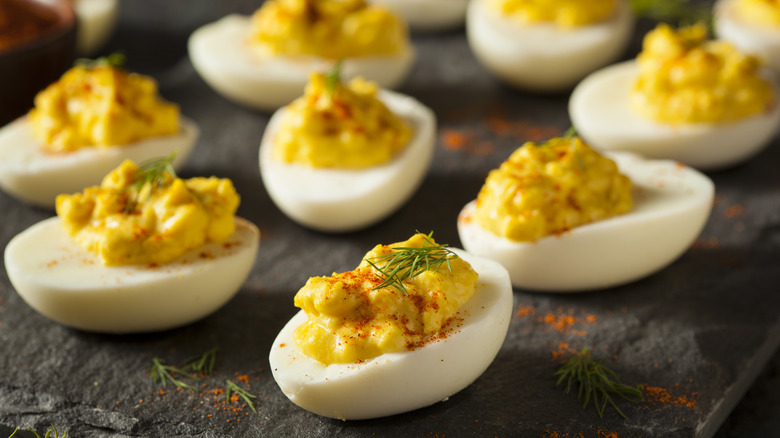 Deviled eggs lay out on black surface