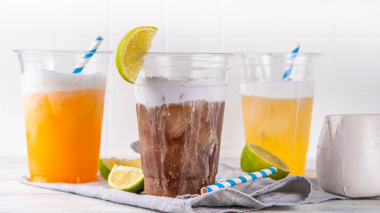 three dirty sodas in plastic cups