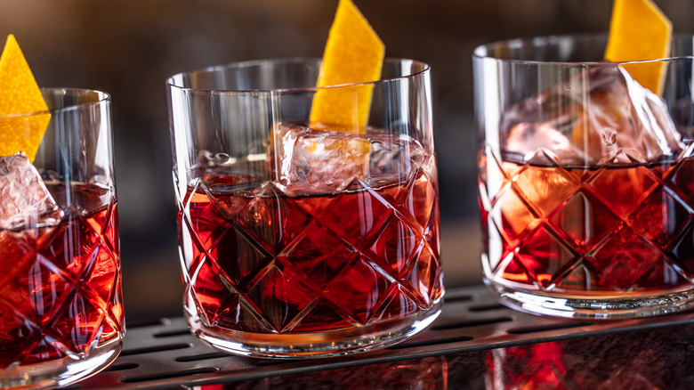 Negronis on a bar in a row