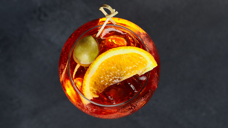 Negroni top down shot with orange and olive garnish