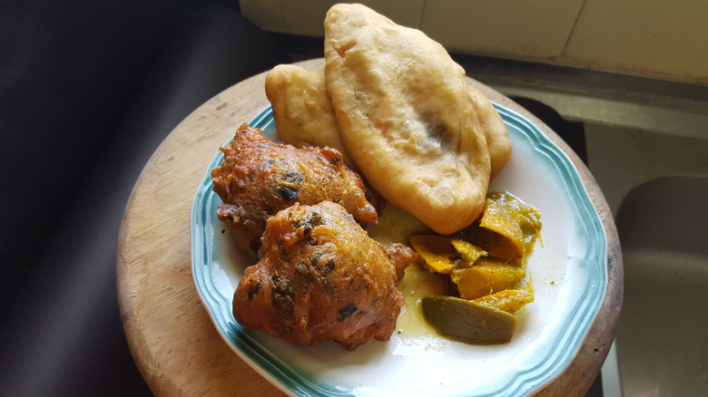 A plate of aloo pies, saheena, and curried mangoes is displayed.