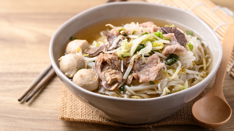 bowl of Thai noodle soup with spoon and chopsticks