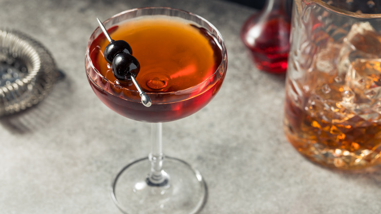 Manhattan in coupe glass with speared cherries