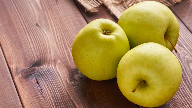 Golden Delicious apples on wood