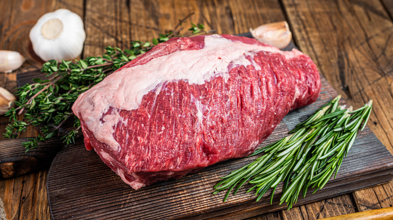 Raw brisket and herbs on a board