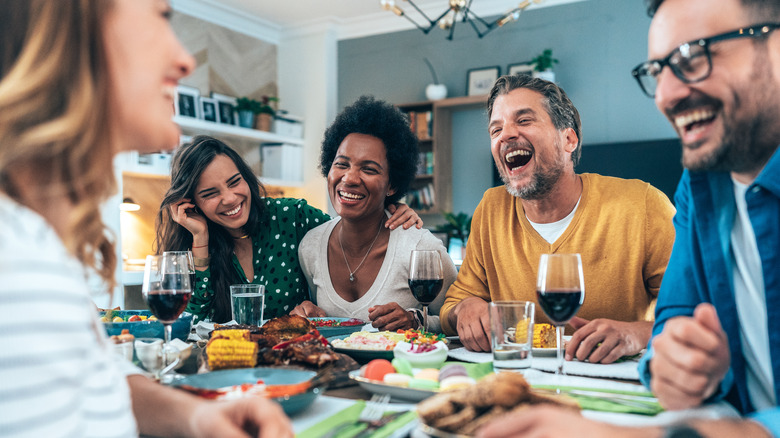 Dinner party guests laughing