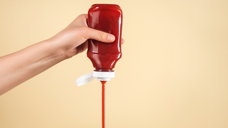 Person squeezing ketchup bottle