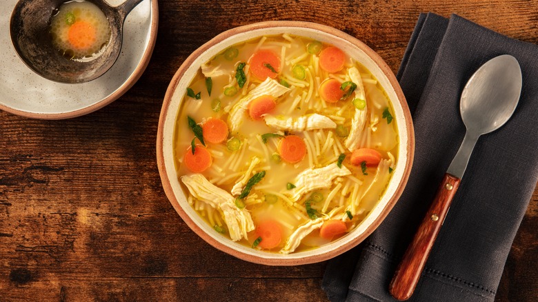 Bowl of chicken noodle soup on wood table 