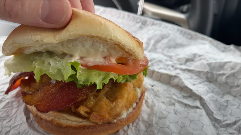 lifting bun to reveal inside of valley crispy chicken club 