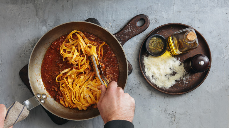 Finishing linguini pasta in ragu sauce