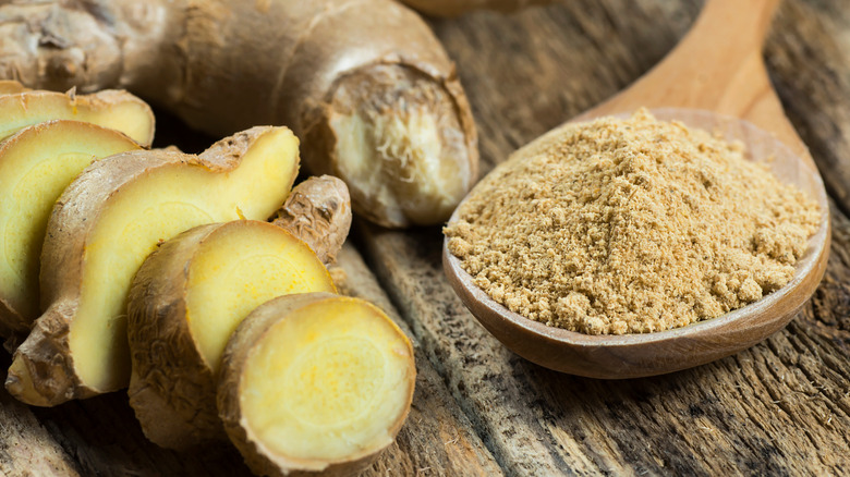 ginger root and dried ginger powder in a wooden spoon