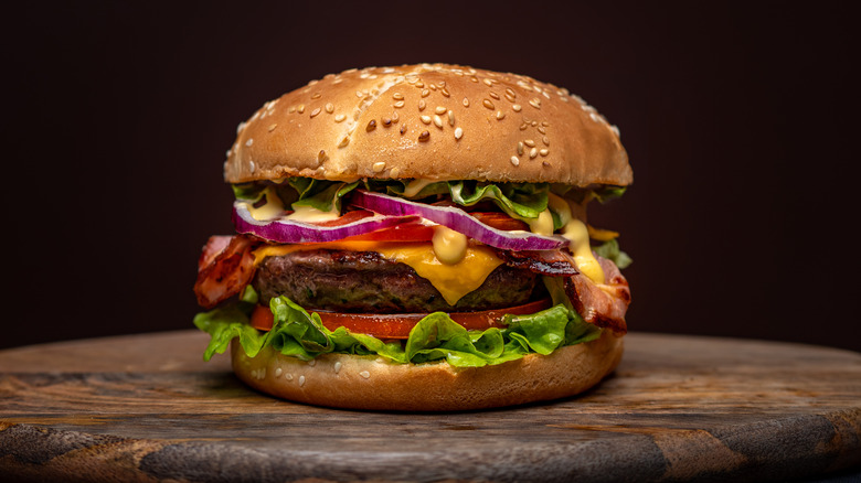 Burger with toppings on wood board