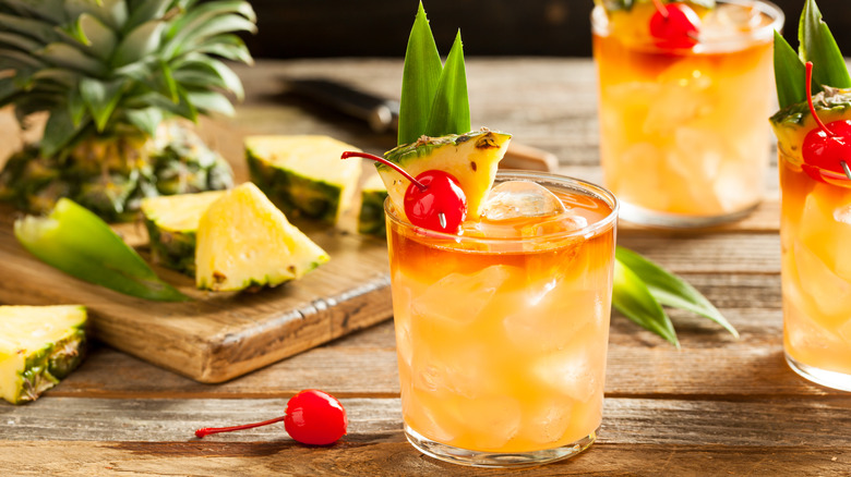 Mai tai cocktails garnished with pineapple slices and pineapple fronds