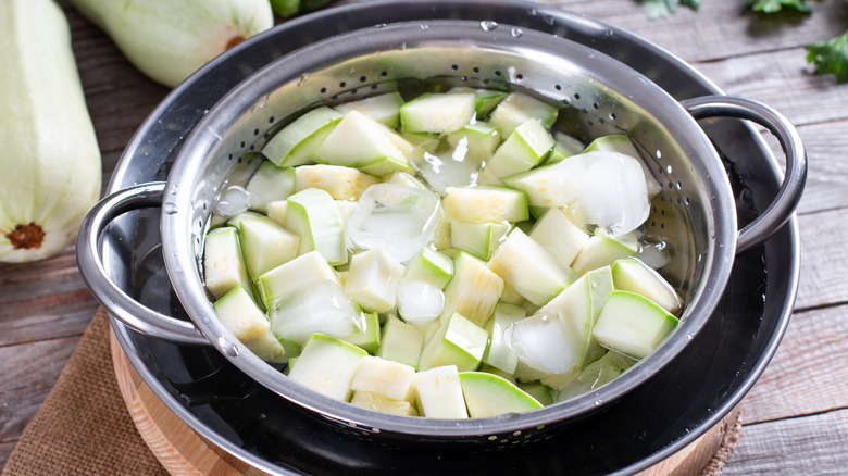 chopped zucchini in ice water