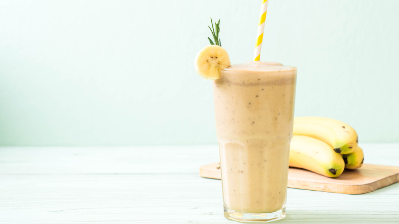 Banana smoothie with bananas in the background