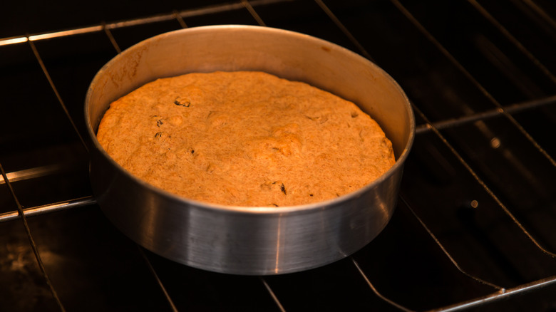 uncovered cake baking in oven