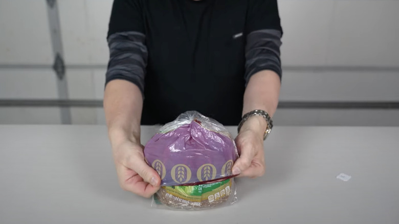 Man folding bag over a loaf of bread